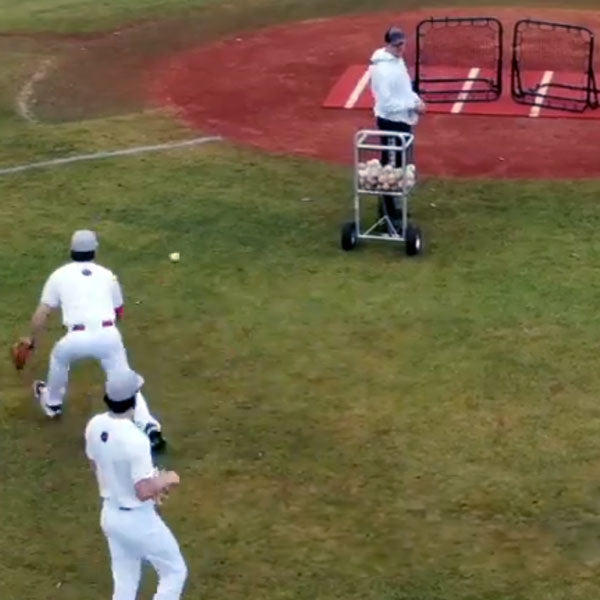 Baseball Players fielding balls off of rebounders